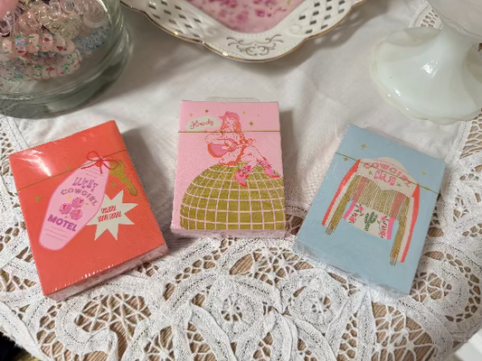 Girlie Playing cards with colorful designs on a lace tablecloth